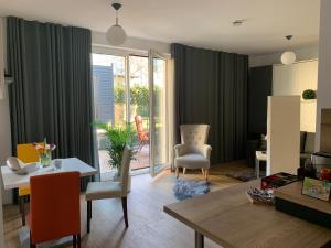 Townhouse Apartment Potsdam في بوتسدام: غرفة معيشة مع طاولة وكراسي وغرفة طعام