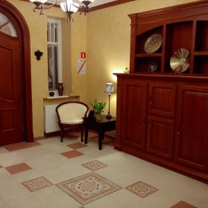 een kamer met een kast, een stoel en een tafel bij Willa Warta in Krynica Morska