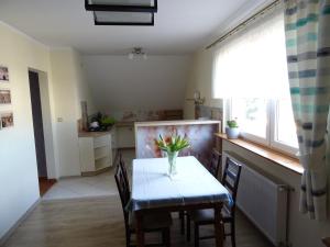 een keuken en eetkamer met een tafel en stoelen bij Cicha 10 Na górze in Ostróda