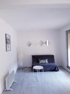 ラ・シオタにあるappartement bord de merの白いベッドルーム(ベッド1台、テーブル付)
