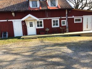 un fienile rosso con una porta bianca e un portico di Ranch Mörby a Stora Mellösa