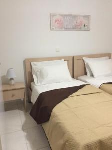 a bedroom with two beds and a table with a lamp at Anatoli View in Agia Marina Nea Kydonias