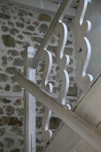 a white railing on a stairs with a stone wall at La Paresse en Douce in Tours-sur-Meymont