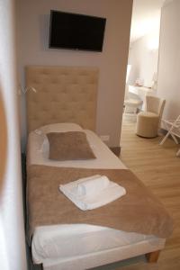 - une chambre d'hôtel avec 2 lits et des serviettes dans l'établissement Le Home, à Belvès