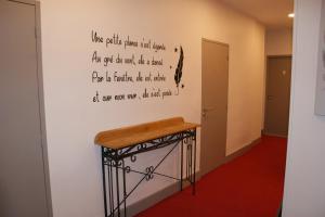 une chambre avec un écrit sur le mur dans l'établissement Le Home, à Belvès