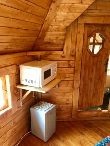 um pequeno quarto com um micro-ondas e um frigorífico em The Nest Glamping Pod em Dalmally