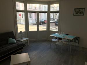 a living room with a couch and a table at Studio 50m Plage in Dunkerque