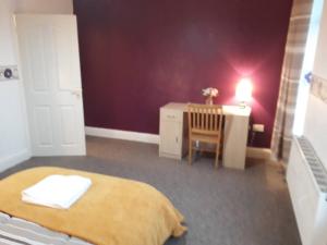 um quarto com uma cama, uma secretária e uma cadeira em Villa Parrin em Manchester
