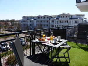 ein Tisch auf einem Balkon mit einem Teller Essen in der Unterkunft Ferienwohnung 14 - Sofia Haus Hühnergott in Ostseebad Sellin