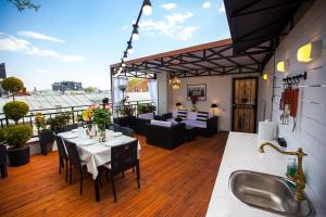 a patio with a table and chairs on a deck at Presidential Suite Prince Machabeli in Tbilisi City