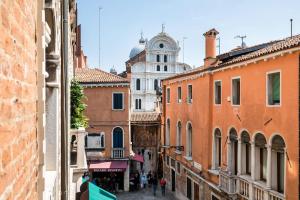 eine Gruppe von Menschen, die eine Stadtstraße entlanggehen in der Unterkunft San Zaccaria Apartment in Venedig