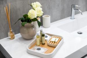 ein Waschbecken mit zwei Flaschen Seife und eine Vase mit Rosen in der Unterkunft San Zaccaria Apartment in Venedig
