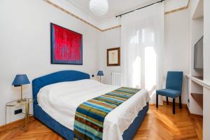 a bedroom with a bed and a blue chair at San Zaccaria Apartment in Venice