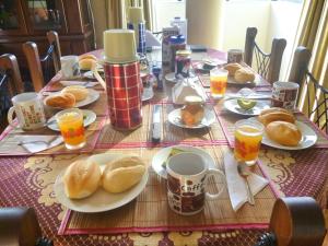 uma mesa com pratos de comida e chávenas de sumo de laranja em Lima Backpackers em Lima