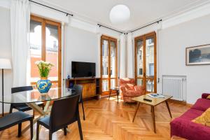 ein Wohnzimmer mit Tisch und Stühlen und einem Fernseher in der Unterkunft San Zaccaria Apartment in Venedig