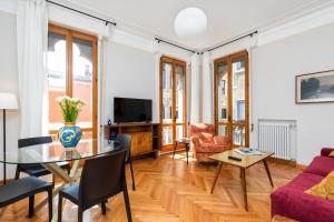 a living room with a table and chairs and a tv at San Zaccaria Apartment in Venice