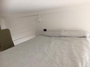 una camera da letto con un letto con copriletto bianco di Monolocale a Riva Ligure