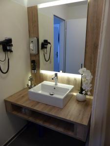 ein Badezimmer mit einem weißen Waschbecken und einem Spiegel in der Unterkunft Ferienwohnung 14 - Sofia Haus Hühnergott in Ostseebad Sellin + 36 Fotos