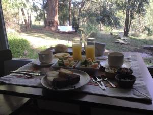 Una mesa con un plato de comida y dos vasos de jugo de naranja. en Entre Sierras B&B, en Tandil 17 fotos más