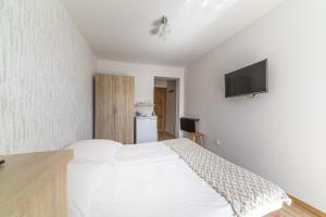 a bedroom with a white bed and a flat screen tv at Willa Litoral in Jastarnia