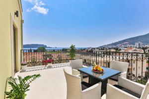 a patio with a table and chairs on a balcony at Hotel Pozzo in Budva