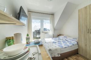 a small bedroom with a bed and a sink at Willa Litoral in Jastarnia