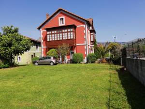 a house with a car parked in front of a yard at Hotel Asturias in Arriondas