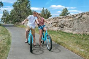 a man and woman riding bikes down a path at Pronghorn Resort in Bend