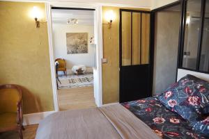 1 dormitorio con 1 cama y puerta que conduce a un pasillo en Gîte de l'Écu, en La Roche-Guyon