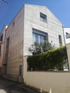 un edificio de ladrillo gris con una ventana y arbustos en La casa di Mario...tra le case Via del Giglio 52, en Ortona
