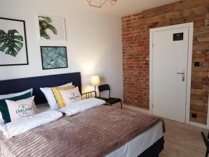 a bedroom with a bed and a brick wall at Enklawa Nord Bałtycki Chillout House in Władysławowo