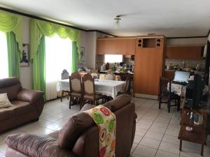 ein Wohnzimmer mit einem Sofa und einem Tisch in der Unterkunft Casa del Suizo in Alajuela