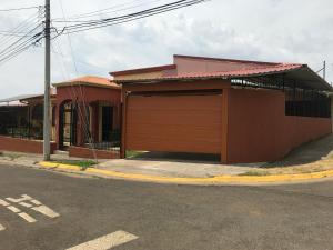 a building with a garage on the side of a street at Casa del Suizo in Alajuela City