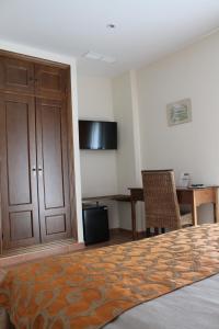 a bedroom with a bed and a table and a desk at Almadraba Conil in Conil de la Frontera