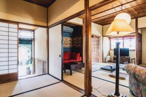 松江市にあるゲストハウス米村家のリビングルーム(赤いソファ、ランプ付)