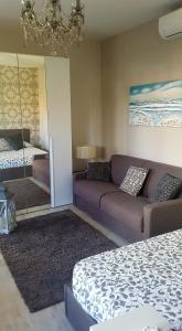 a room with a couch and a bed and a mirror at Versilia Apartment in Forte dei Marmi