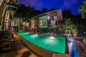 an image of a swimming pool in front of a house at The Sanctuary Langkawi in Pantai Cenang