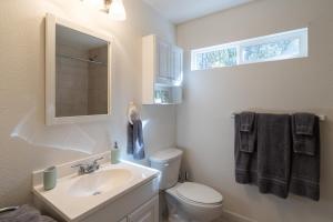 a bathroom with a sink and a toilet and a mirror at Mauna Nani in Volcano +19 photos