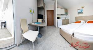 ein Schlafzimmer mit einem Bett und einem Schreibtisch sowie eine Küche in der Unterkunft Villa Lozica in Rogoznica