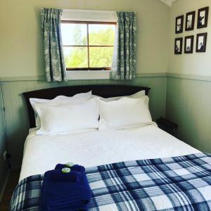 uma cama com um saco azul sentado em cima dela em The Shepherd's Rest em Oamaru