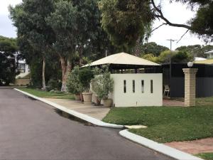 un edificio blanco con un cenador en una calle en Bayview Motel, en Esperance