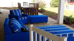 un par de sillas azules y una mesa en un porche en Villa de Colores 3 Rooms 5 king Beds, en Sosúa