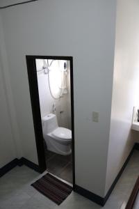 a bathroom with a white toilet and a mirror at Keen's Place in Puerto Princesa City +31 photos