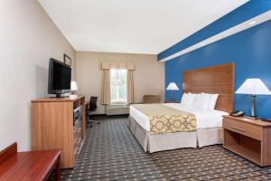 a hotel room with a bed and a flat screen tv at Baymont by Wyndham Jacksonville/Butler Blvd in Jacksonville