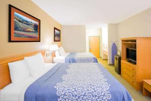 a hotel room with two beds and a television at Days Inn by Wyndham Hattiesburg MS in Hattiesburg