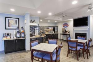 a dining room with a table and chairs and a kitchen at Baymont by Wyndham Jacksonville/Butler Blvd in Jacksonville