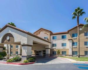 um grande edifício de apartamentos com uma palmeira em Comfort Suites Bakersfield em Bakersfield