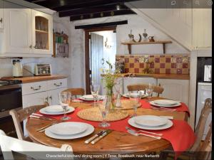 ClynderwenにあるY Terasのキッチン(木製テーブル、皿、ワイングラス付)