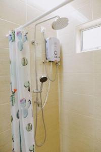 een douche in een badkamer met een douchegordijn bij Yellow Cube at Lumut Cube Homestay Kontena in Lumut