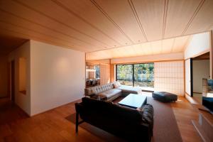 ein Wohnzimmer mit einem Sofa und einem Tisch in der Unterkunft Aoi Suites at Nanzenji Modern & Traditional Japanese Style in Kyoto